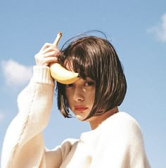 a woman holding a banana up to her face