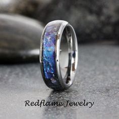 a wedding ring with blue and purple opal inlaying the inside of it