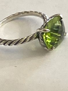 Previously USED  David Yurman Cushion Ring size 7 100% AUTHENTIC  COLOR STONE RING COLLECTION  Ring has been cleaned  Estimated Retail $395-$695 12mmx10mm  Faceted Center Stone  PERIDOT  -DY Checkerboard Faceting  925 Sterling Silver    usps Signature+ Insurance   Item must be packed in original condition and packed with original contents Luxury Peridot Ring For Formal Occasions, Luxury Oval Peridot Rings, Luxury Peridot Rings With Accent Stones, Green Stackable Rings For Formal Occasions In May, Green Stackable Rings For Formal May Birthstone, Elegant Green Crystal Solitaire Ring, Green Formal Stackable Rings For May Birthstone, Elegant Green Solitaire Crystal Ring, Elegant Lime Green Rings For Gift