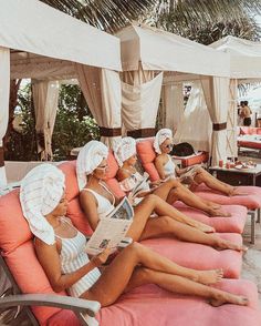 there are many women sitting on pink couches with towels around their heads and feet