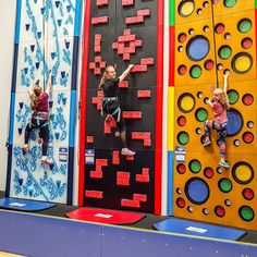 two children are climbing up and down the wall in an indoor climbing gym with colorful walls