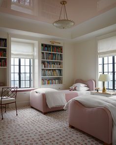 there are two beds in the room with bookshelves