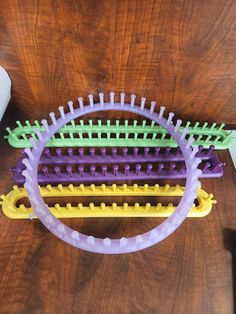 three plastic combs sitting on top of a wooden table