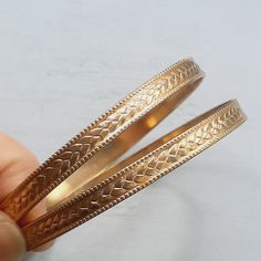 A PAIR of matching goldtone metal bangles, c.1970s in date. The bangles are slim, approx. 6mm wide in sturdy goldtone metal. The metal has a slight patina to it and is quite a rich gold colour. Approx. 68mm across inside. In excellent vintage condition, please see all photos. For more gorgeous vintage jewelry, please see my shop: http://www.etsy.com/shop/RagtimeBazaar?ref=si_shop Please be aware that I'm based in the UK, so international orders will take longer to arrive. Vintage Yellow Gold Brass Bangle, Gold Metal Bangle For Anniversary, Vintage Gold Brass Bangle, Vintage Gold Adjustable Bangle, Adjustable Vintage Gold Bangle, Vintage Yellow Gold Metal Bangle, Antique Gold Metal Bangle, Gold Hoop Bangle In Metal, Vintage Metal Bangle For Anniversary