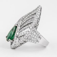 Lovely emerald with diamond cocktail ring.  5.15 carats total gemstone weight. 3.12 carat pear shape emerald apx F3. Complimented with 238 round brilliant and baguette cut diamonds, 5.03ct. Approximately G/H color and SI clarity. 13.60 grams, in 18k white gold, current ring size 7. Accommodated with an up-to-date digital appraisal by a GIA G.G. once purchased, upon request. Please contact us with any questions. Luxury Pear-shaped Diamond Ring With 17 Jewels, Luxury Pear-shaped Brilliant Cut Emerald Ring, Luxury Marquise Emerald Ring With Diamonds, Luxury Pear-shaped Emerald Ring For Formal Occasions, Luxury Marquise Emerald Ring, Luxury Emerald Pear-shaped Jewelry, Luxury Pear-shaped Emerald Ring With Prong Setting, Luxury Pear-shaped Emerald Jewelry, Formal Pear-shaped Emerald Ring In White Gold