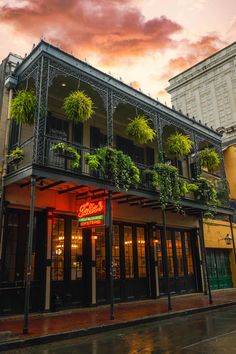 an old building with plants growing on it's balconies and windows at dusk