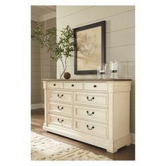 a white dresser sitting in front of a mirror