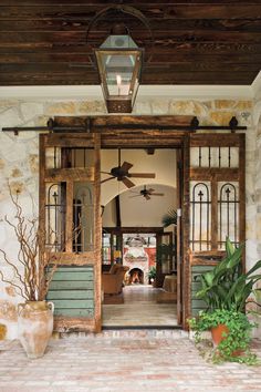 an open door leading into a room with plants and potted plants on the outside