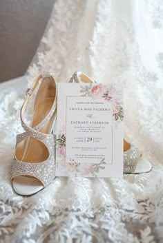 a pair of shoes and a card sitting on top of a bed