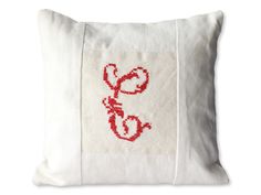 a white pillow with red stitching on the front and back of it that says love