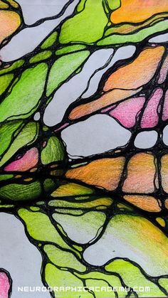 a close up view of a stained glass window with green, pink and yellow colors