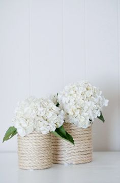 two baskets with flowers in them sitting on a white counter top next to each other