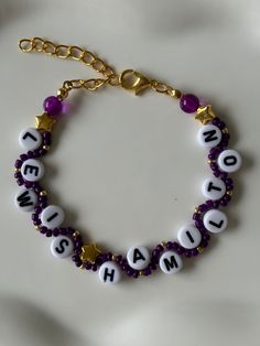 a purple and white beaded bracelet with words on it