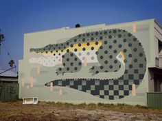 a large mural on the side of a building with a crocodile painted on it's side