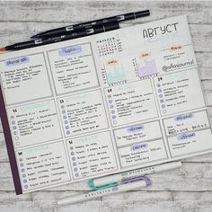 an open planner and pen sitting on top of a wooden table