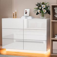 a white dresser sitting next to a book shelf