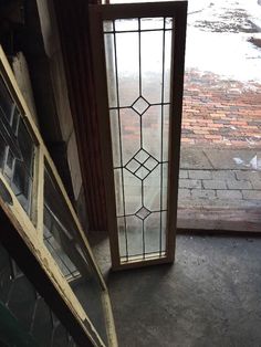 two stained glass windows sitting next to each other on the floor in front of a brick building