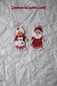 two christmas ornaments are hanging on a white sheet