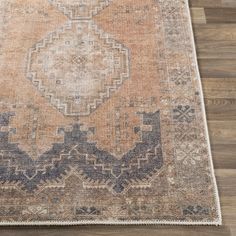 an orange and blue area rug on a wooden floor with wood floors in the background