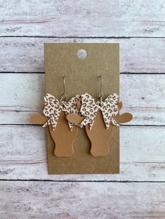 two brown and white animal print earrings on top of a card