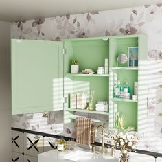 a bathroom with green cabinetry and floral wallpaper on the walls, along with white counter tops