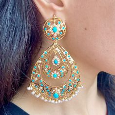 Design inspired from the Edwardian Era, these handcrafted jadau earrings have been made in sterling silver with 22K gold plating and embellished with freshwater pearls and turquoises. The earrings have a clip at the back and a threaded screw. Weight : 50 GMs, Height : 10 cm, Width : 5.5 cm Elegant Turquoise Kundan Earrings, Turquoise Kundan Chandbali Earrings, Turquoise Kundan Earrings For Festivals, Festive Kundan Turquoise Earrings, Turquoise Kundan Earrings For Wedding, Festive Turquoise Kundan Earrings, Turquoise Jewelry With Matching Earrings For Festivals, Elegant Turquoise Earrings For Festivals, Elegant Turquoise Earrings For Festive Occasions