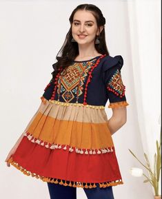 This top/kurti has beautiful handmade embroidery, vibrant colors and pom pom trip. Traditional Blouse With Tassels For Festive Occasions, Traditional Festive Blouse With Tassels, Festive Traditional Blouse With Tassels, Cotton Short Sleeve Blouse With Tassels, Cotton Blouse With Tassels And Short Sleeves, Traditional Multicolor Cotton Embroidered Top, Short Sleeve Cotton Blouse With Tassels, Embroidered Multicolor Tunic, Multicolor Bohemian Blouse With Tassels