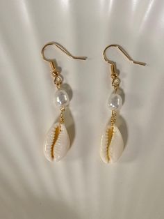 - Gold plated ✨ - Lead and nickel free 🤍 - Real cowrie seashell 🐚 - Each seashell is unique and straight from the ocean/beach 🏝️ - Please note that sometimes seashells have impurities -- they are imperfectly perfect 💖 Cheap Shell Drop Earrings, Cheap Beige Earrings For Beach, Cowrie Shell Dangle Earrings As Gift, White Shell Drop Earrings For Summer, White Bohemian Dangle Shell, Elegant Shell Jewelry For Beach Season, Bohemian White Dangle Shell, Beach Jewelry For Pierced Ears, Shell-shaped, Shell-shaped Beach Jewelry With Ear Wire