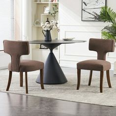 a dining room table with two chairs and a vase on the top, in front of it