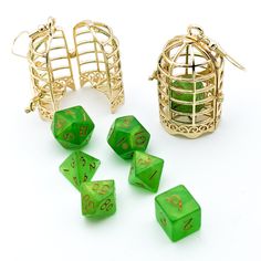 green dice with numbers on them sitting next to a gold cage and birdcage