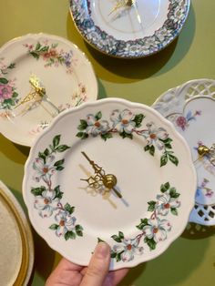 a person holding a plate with a clock on it and other plates in the background