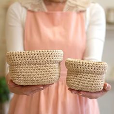 a woman is holding two baskets in her hands, both made out of woven material