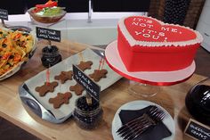 a wooden table topped with lots of cakes and desserts