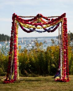 an outdoor wedding ceremony setup with flowers on the grass and water in the background,