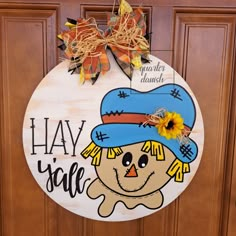 a wooden sign that says hay y'all with a scarecrow hat on it