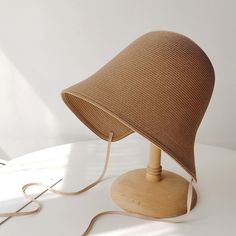 a wooden table lamp with a cord attached to it's base on a white surface