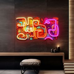 a neon sign that says love is displayed on the wall next to a bench and stool