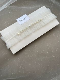 a white wedding garter with pearls on it