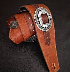 Amazing leather strap combined in shades of Brown with engraved conchos and adjustable buckle. It will definitely exceed your expectations in comfort and style!   Specifications:  ✓ 100% genuine leather ✓ Width: 2.76"  ✓ Length: adjustable with buckle ✓ Inner reinforcement ✓ Metal engraved conchos  ✓ Metallic engraved buckle ✓ Reinforced holes and eyelets  ✓ Stitched and glued ✓ Covered with top-quality leather ✓ Handcrafted . This strap is entirely handcrafted. All parts are designed, cut and p Leather Concho Belt Buckles For Rodeo, Adjustable Western Concho Belt Buckles, Western Leather Belts And Suspenders With Concho, Adjustable Leather Concho Belt, Classic Adjustable Hand Tooled Belt, Classic Adjustable Hand-tooled Belt, Adjustable Leather Belt For Rodeo, Adjustable Leather Belts For Rodeo, Adjustable Brown Belt With Buckle Closure