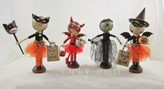 three small figurines are dressed up in halloween costumes and holding trick - or - treat bags