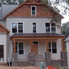 a house being built in the woods with lots of wood and stone on the ground