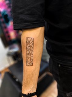 a man with a tattoo on his arm that is made up of lines and waves