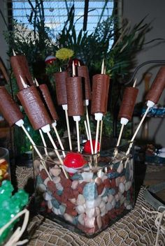 chocolate covered candy pops are arranged in a bowl with rocks and candies on them