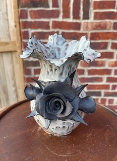 a white vase sitting on top of a wooden table