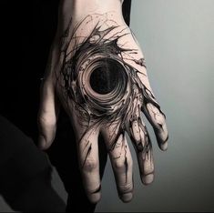 a person's hand with a black and white tattoo on it