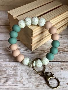 a wooden box with a pair of scissors on it and a bracelet made out of beads