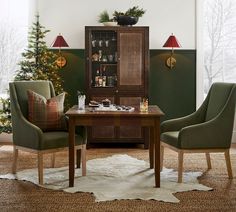 a dining room table with two chairs and a hutch next to it in front of a christmas tree