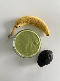 an avocado and banana sitting next to each other on a white table top