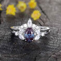 a close up of a ring on a wooden surface with flowers in the back ground