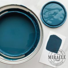 a blue paint can and some white paper on a table with two different colors of paint